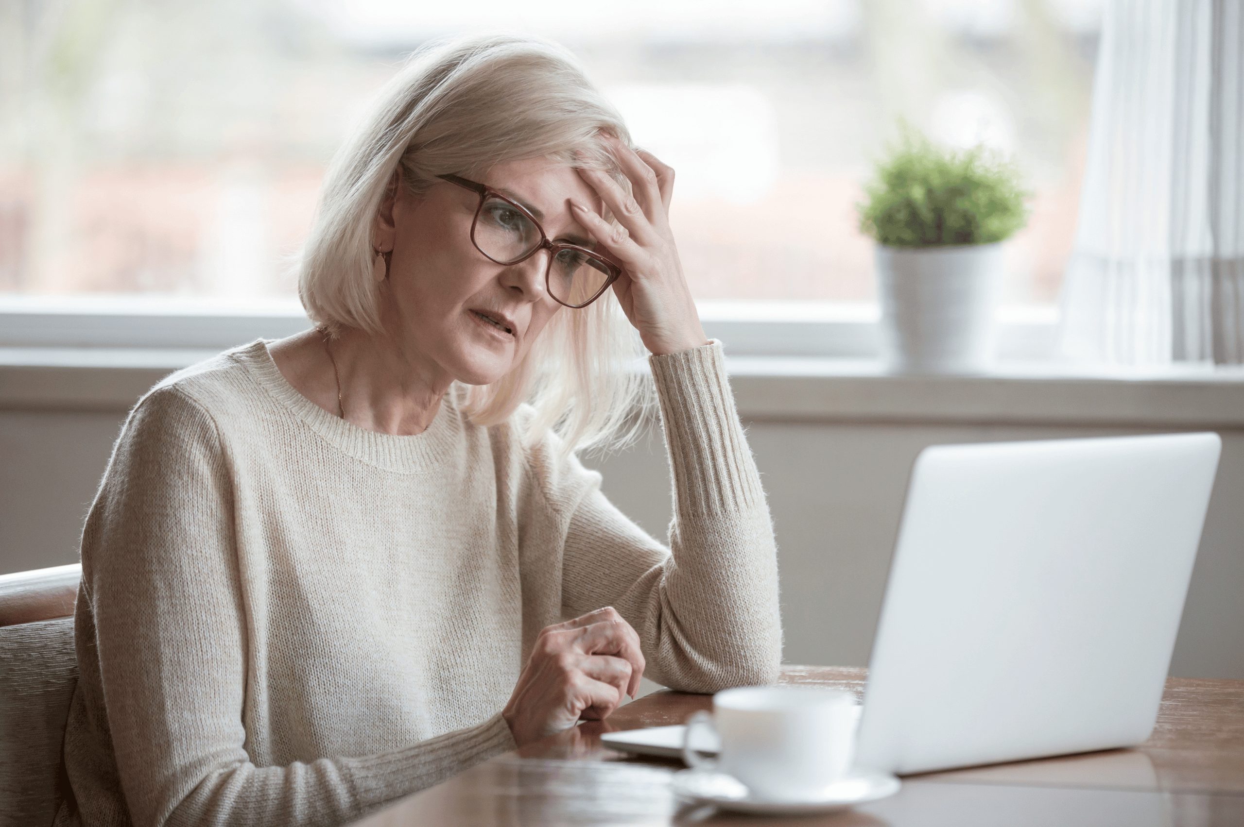Confused mature woman looking at a website in a laptop