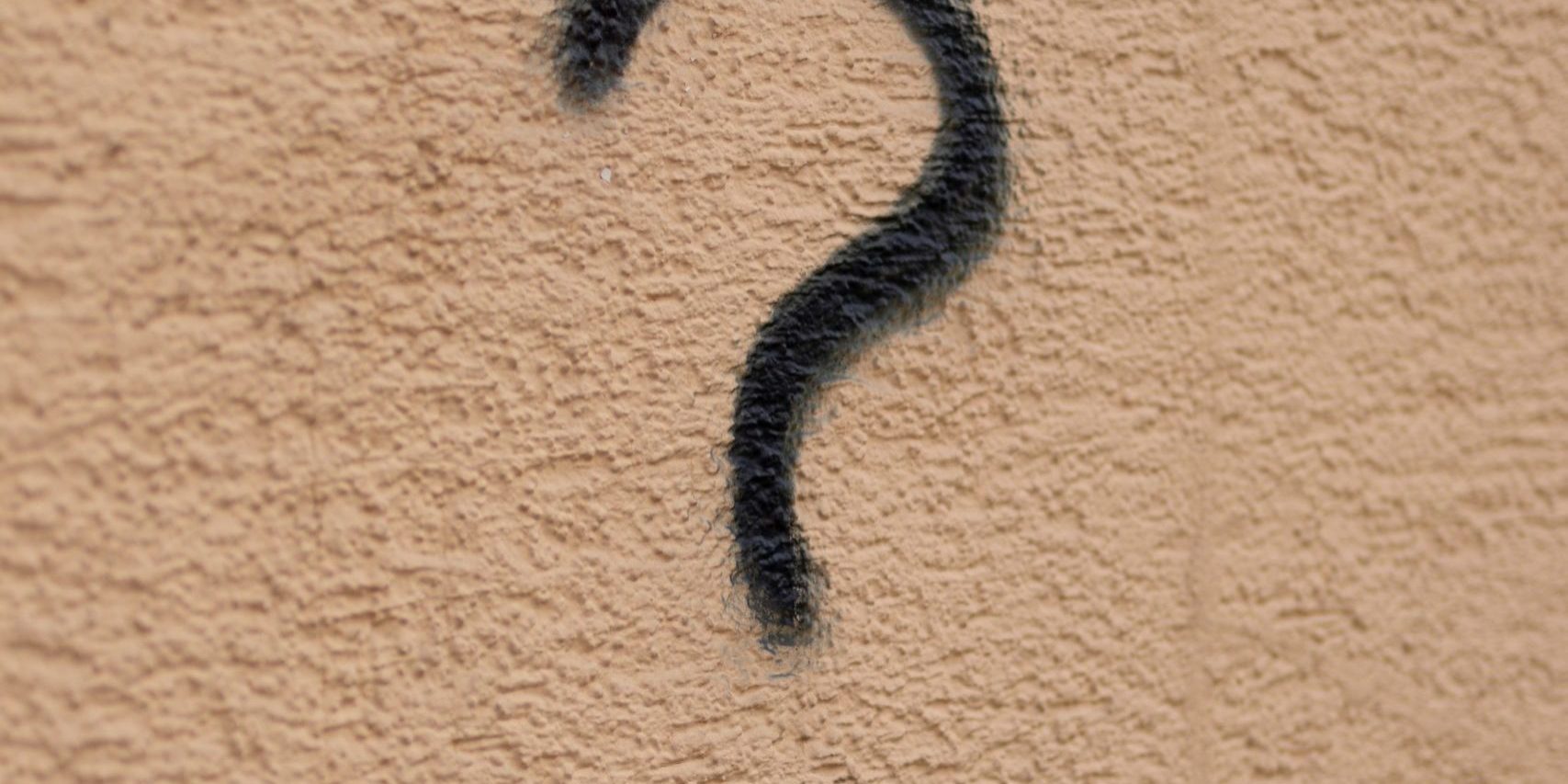 Black question mark on a brown background